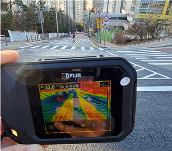 친환경 열선시스템이 설치된 도로에서 열화상 카메라를 이용해 기온 급강하 시 시스템이 작동되는 상태를 점검하고 있다.