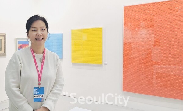 지난 2월 서울 강남구 삼성동 코엑스 3층 C홀에서 열린 서울국제아트엑스포 행사장에서 이영아 작가가 선연시리즈 작품 앞에서 기념촬영을 하고 있다.[사진=서울시티]