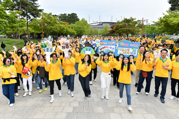 Participants are waving signs that announce the “Clean Action in Daily Life Campaign” while walking along the path of the walkathon. The core of the campaign is to use multi-use items instead of disposable ones and actively use public transportation to practice carbon reduction in our daily life.