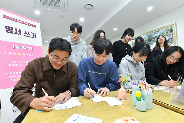 참석자들이 부대행사장에서 부모님께 감사하는 마음을 엽서에 담고 있다. (사진제공=하나님의교회)