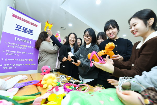 힐링세미나 참석자들이 포토존에서 다양한 촬영 소품을 고르며 즐거운 한때를 보내고 있다. (사진제공=하나님의교회)