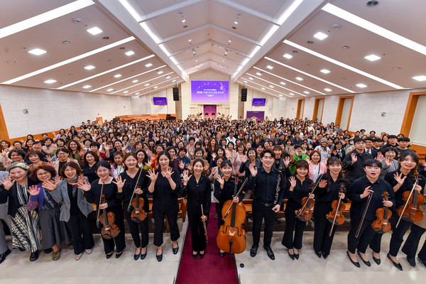 18일 '서울동대문 하나님의 교회'에서 열린 연주회에 참석한 관객과 연주자들이 환한 미소와 함께 기념촬영을 하고 있다. (사진제공=하나님의교회)
