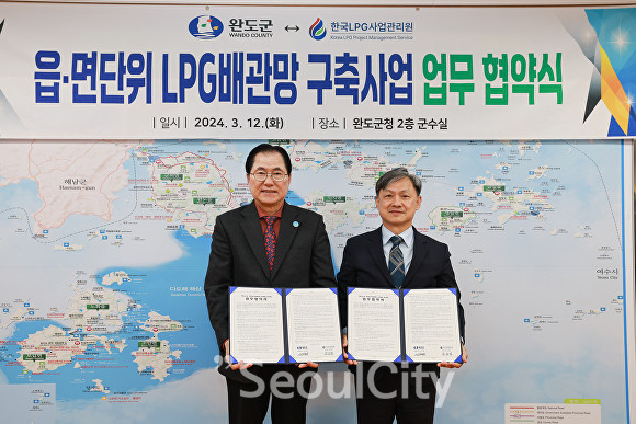 신우철 완도군수(왼쪽)이 한국LPG사업관리원과 읍면 단위 LPG 배관망 구축 사업 추진을 위한 업무 협약을 체결하고 기념사진을 찍고 있다./완도군 제공