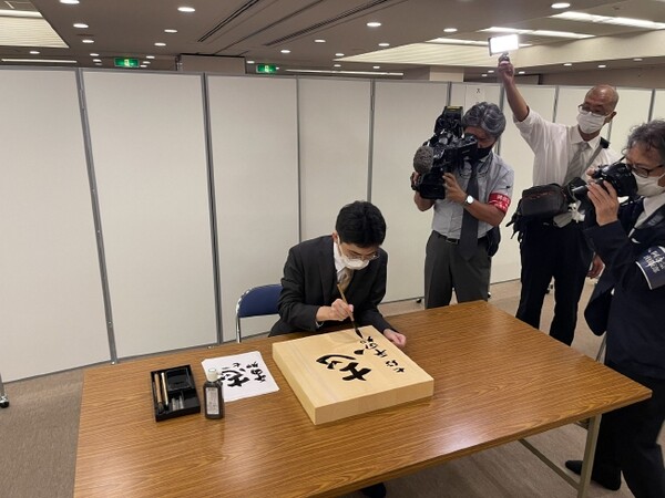 바둑판에 사인을 하는 히라타도모야(사진=일본기원)