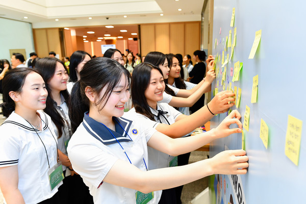 인성특강에는 포토존, 포스트잇 한마디, 패널전시 등 부대행사가 마련됐다. 청소년들이 친구들에게 전할 메시지를 메모지에 적어 붙이고 있다. (사진제공=하나님의교회)