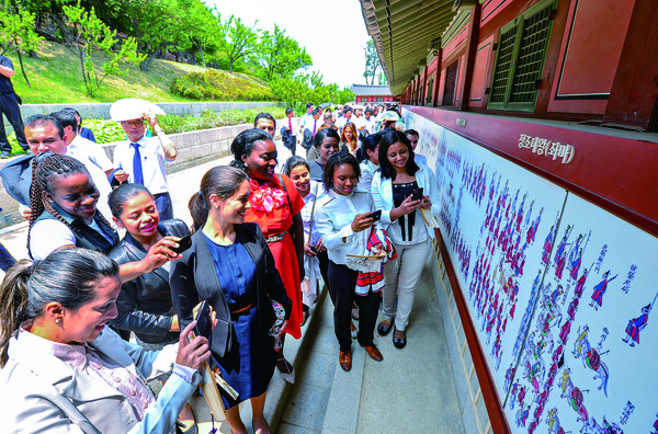 하나님의 교회 63차 해외성도방문단이 수원 화성을 방문했다. 중남미, 유럽, 아프리카에서 방한한 이들이 정조대왕의 행차모습을 담은 행렬도를 흥미롭게 살피며 카메라에 담고 있다. (사진제공=하나님의교회)