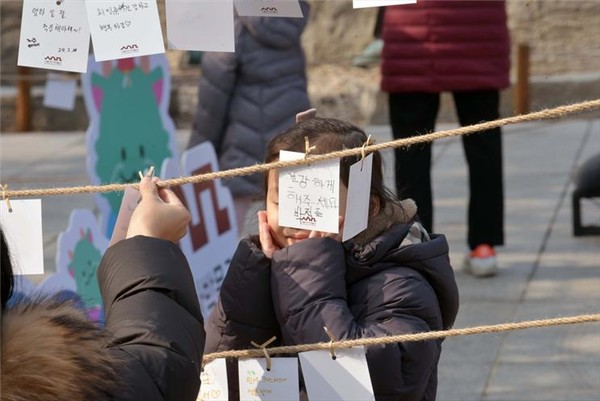 서울역사박물관 '설맞이 한마당'에서 펼쳐진 소원지에 소원을 적은 시민(2024) (출처=서울시 문화본부)