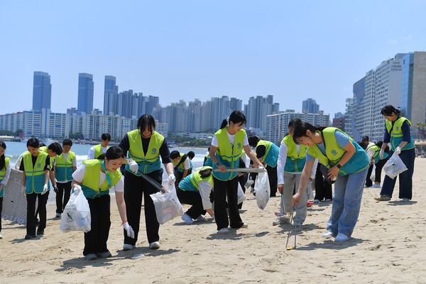 ASEZ WAO 회원들이 부산 광안리해수욕장 모래사장 곳곳에 버려진 폐플라스틱과 생활쓰레기, 폐기물을 수거하고 있다. 이번 활동은 ASEZ WAO의 '2040 플라스틱 프리' 캠페인 일환이다. (사진제공=하나님의교회)