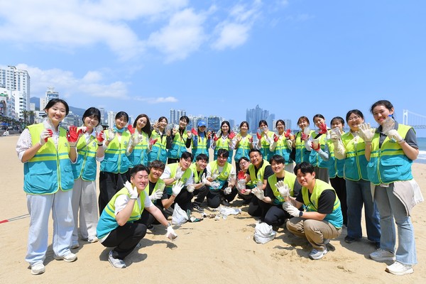 ASEZ WAO가 '2040 플라스틱 프리' 캠페인의 일환으로 25일 부산 광안리해수욕장에서 거리캠페인과 정화활동을 펼쳤다. 회원들이 수거한 폐플라스틱을 들고 플라스틱 오염 근절에 함께하자는 메시지를 전하고 있다. (사진제공=하나님의교회)